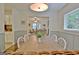Traditional dining room with a wooden table, white chairs, and an open view to the living room at 345 Summer Pl, Peachtree City, GA 30269