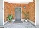 Inviting front porch with plants highlighting the stylish front door, decorative exterior light, and tiled floor at 345 Summer Pl, Peachtree City, GA 30269