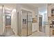 Bright kitchen with stainless steel refrigerator, white cabinets, and view to the entry hallway at 345 Summer Pl, Peachtree City, GA 30269