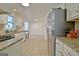 Well-lit kitchen featuring white cabinets, granite countertops, stainless steel appliances, and tile flooring at 345 Summer Pl, Peachtree City, GA 30269