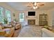 Inviting living room with a brick fireplace, large windows, plush seating, and warm lighting at 345 Summer Pl, Peachtree City, GA 30269