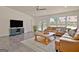 Open living room with hardwood flooring, large windows, and a brown leather sofa at 345 Summer Pl, Peachtree City, GA 30269