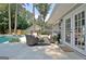 Outdoor patio with lounge seating overlooking the swimming pool and landscaped backyard at 345 Summer Pl, Peachtree City, GA 30269