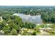 An aerial view shows home on a large lot with water views and a lush tree canopy at 1919 Lake Lucerne Sw Way, Lilburn, GA 30047