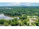 Expansive aerial view features a lakefront home surrounded by lush greenery and serene waterfront with a distant mountain view at 1919 Lake Lucerne Sw Way, Lilburn, GA 30047