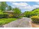Long driveway leading to a brick and stone home with lush landscaping at 1919 Lake Lucerne Sw Way, Lilburn, GA 30047