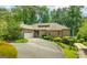 Stunning exterior of a brick home with a paved driveway and attached garage surrounded by mature trees and landscaped grounds at 1919 Lake Lucerne Sw Way, Lilburn, GA 30047