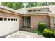 Welcoming front exterior of a brick home with a garage, beautiful landscaping and a charming entranceway at 1919 Lake Lucerne Sw Way, Lilburn, GA 30047