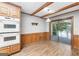 Eat-in kitchen with wood beams and cabinets, and sliding door to backyard at 1919 Lake Lucerne Sw Way, Lilburn, GA 30047