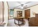 Spacious office featuring a round wooden table, shelving, and a ceiling fan at 1919 Lake Lucerne Sw Way, Lilburn, GA 30047