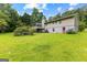 Exterior view of home's backyard with lush lawn and mature trees at 110 Mourning Dove S Dr, Fayetteville, GA 30215