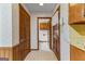 Hallway with wood paneling, vintage wallpaper, and access to the kitchen at 110 Mourning Dove S Dr, Fayetteville, GA 30215