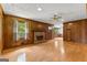 Inviting living room featuring a brick fireplace, wood paneling, and hardwood floors at 110 Mourning Dove S Dr, Fayetteville, GA 30215