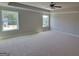 Spacious carpeted bedroom featuring tray ceilings, neutral walls, and natural light from two windows at 45 Duffy Dr., Mcdonough, GA 30253
