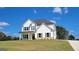 Newly constructed two-story home with white siding, dark roof, front porch, and manicured lawn on a sunny day at 45 Duffy Dr., Mcdonough, GA 30253