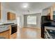 Bright kitchen with laminate wood floors, natural wood cabinets, and black appliances at 1735 Deer Crossing Cir, Jonesboro, GA 30236