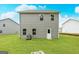 Rear exterior of home featuring vinyl siding, double hung windows, a door and a well manicured lawn at 282 Limestone Circle, Conyers, GA 30013