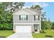 Charming two-story home with gray siding, a white garage door, and a well-manicured lawn at 282 Limestone Circle, Conyers, GA 30013