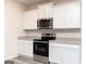 Contemporary kitchen boasts stainless steel appliances, white cabinetry, and stone countertops at 282 Limestone Circle, Conyers, GA 30013