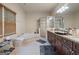 Bright primary bathroom featuring a large vanity with granite countertops, a soaking tub, and a tiled shower at 1484 Mcpherson Se Ave, Atlanta, GA 30316