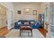 Comfortable living room with hardwood floors, featuring a blue sofa, artworks, and a wooden coffee table at 1484 Mcpherson Se Ave, Atlanta, GA 30316