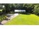 An aerial view showcasing the home, a wide green lawn, and a long driveway at 1833 S Highway 92, Fayetteville, GA 30215