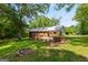 Exterior shot of the home showing a backyard with an in-ground brick barbecue and wooded lot at 1833 S Highway 92, Fayetteville, GA 30215