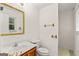 Bright bathroom with a sink, toilet, mirror, towel rack, and window, offering essential amenities at 1833 S Highway 92, Fayetteville, GA 30215