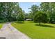 A long driveway leads to a charming home nestled amongst mature trees and a green yard at 1833 S Highway 92, Fayetteville, GA 30215