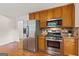 Kitchen features stainless steel appliances, wood cabinets, granite countertops and hardwood floors at 1833 S Highway 92, Fayetteville, GA 30215