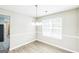 Bright dining room with wood-look floors and a modern chandelier fixture at 2655 Virginia Cv, Riverdale, GA 30296