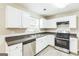 Well-lit kitchen with white cabinets, stainless steel appliances, and new hard surface floors at 2655 Virginia Cv, Riverdale, GA 30296
