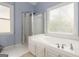 Bathroom with a glass-enclosed shower, soaking tub, and frosted window for privacy at 539 Riverbirch Trce, Stone Mountain, GA 30087
