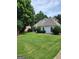 Side view of home featuring a meticulously manicured lawn and manicured greenery at 2911 Chesterfield Se Way, Conyers, GA 30013