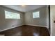 The gray bedroom has wood-look floors and two windows at 8436 Magnolia Dr, Jonesboro, GA 30238