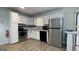 Functional kitchen featuring white cabinets, stainless steel appliances, and light tile flooring at 8436 Magnolia Dr, Jonesboro, GA 30238