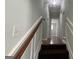 A staircase leads to an upstairs hallway with wood railing at 8436 Magnolia Dr, Jonesboro, GA 30238