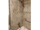 Close-up of shower stall featuring neutral tile, decorative border, and shower head at 177 Northwind Sw Ct, Lilburn, GA 30047
