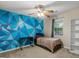Well-lit bedroom features a colorful accent wall, carpeted floor, and a ceiling fan at 539 Horseshoe Cir, Stockbridge, GA 30281