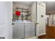 Well-equipped laundry room with washer, dryer, and overhead shelving for storage at 539 Horseshoe Cir, Stockbridge, GA 30281