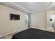 Bright primary bedroom with ensuite access features a wall mounted TV, neutral walls, and carpeted floors at 539 Horseshoe Cir, Stockbridge, GA 30281