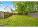 Large backyard with lush green grass and wooden fencing, offering ample space for recreation and privacy at 10044 Point View Dr, Jonesboro, GA 30238