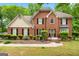 Charming brick home featuring black shutters, complemented by lush landscaping and mature trees at 10044 Point View Dr, Jonesboro, GA 30238