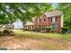 A view of the front of the brick home surrounded by mature trees and landscaping at 10044 Point View Dr, Jonesboro, GA 30238