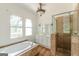 A well-lit bathroom featuring a soaking tub, a shower, and a vanity with ample storage at 1493 Vesta Ave, Atlanta, GA 30337