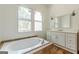 A bright bathroom featuring a tub with tile surround and a vanity with modern fixtures at 1493 Vesta Ave, Atlanta, GA 30337