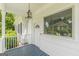 Close-up of a charming covered front porch with stylish lighting and a decorative front door at 1493 Vesta Ave, Atlanta, GA 30337
