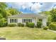 Charming one-story home with white siding, black shutters, and lush green landscaping at 1493 Vesta Ave, Atlanta, GA 30337