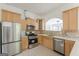 Well-equipped kitchen featuring stainless steel appliances, tile backsplash, and light wood cabinets at 1493 Vesta Ave, Atlanta, GA 30337