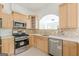 Stylish kitchen featuring stainless steel appliances, ample cabinet space, and a view to the living area at 1493 Vesta Ave, Atlanta, GA 30337